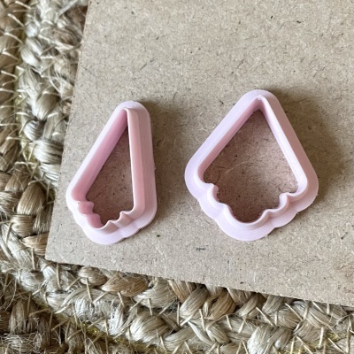 Cortadores de biscoitos rosa em forma de cone de gelado sobre madeira e tapete de fibra