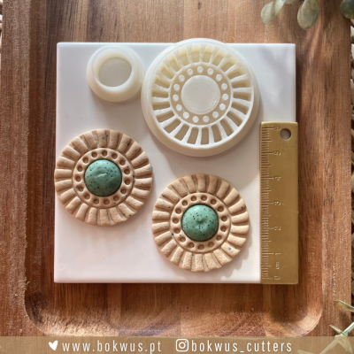 Molde de silicone com formas circulares e régua amarela sobre madeira