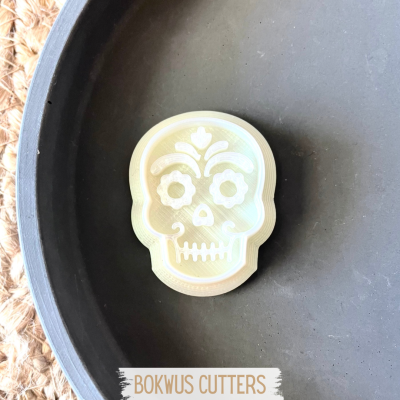 Cortador de bolachas em forma de caveira branca dentro de prato preto