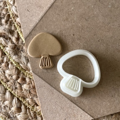 Cortador de biscoitos em forma de cogumelo com biscoito cortado e textura visível