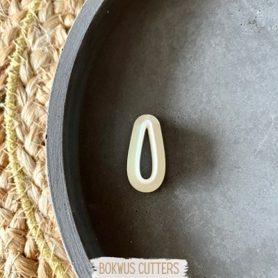 Clips de cabelo brancos em prato cinzento sobre ráfia com texto BOKWUS CUTTERS