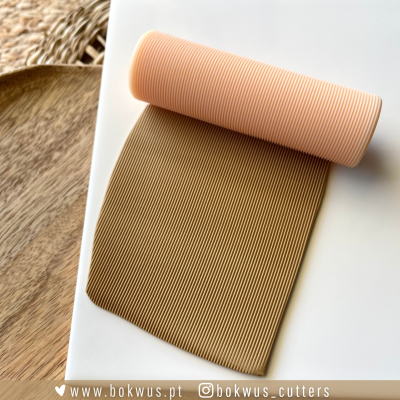 Cortador de massa rosa com padrão de ranhuras sobre superfície branca