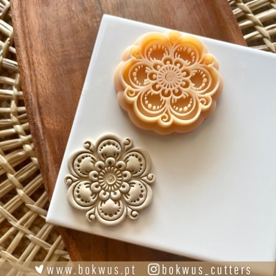 Sabonete moído com padrão floral em placa branca e fundo de madeira e rattan