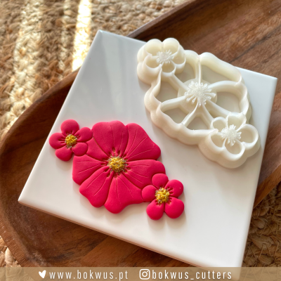 Molde plástico branco para flores e flores vermelhas feitas em pasta sobre base branca