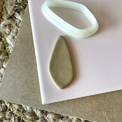 Forma de cortador branco e peça cortada em massa bege sobre superfícies rosa e castanha