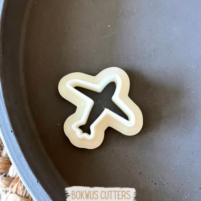 Cortador de bolachas em forma de avião em prato cinza