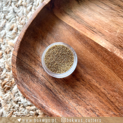 Recipiente plástico pequeno com partículas amarelas sobre bandeja de madeira