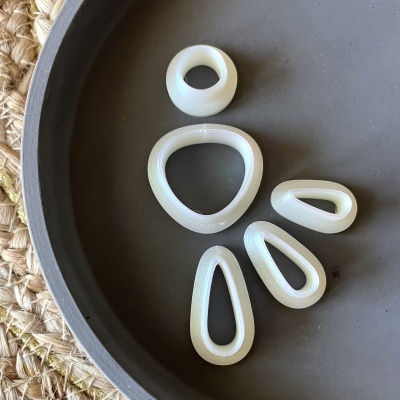 Cinco peças brancas de formas geométricas dispostas num prato cinzento