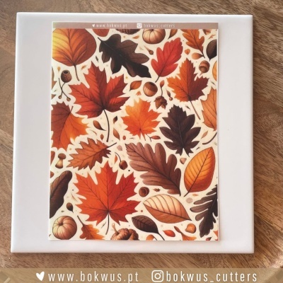 Cartão com padrão de folhas de outono e bolotas sobre superfície branca e madeira clara