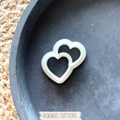Cortadores de biscoitos em forma de coração branco em superfície preta