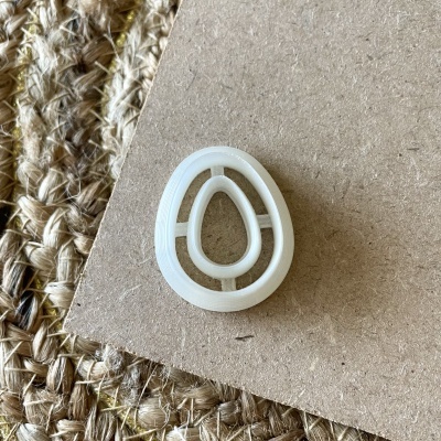 Botão oval branco translúcido com design de ovo em cartão castanho