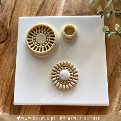 Três moldes de corte decorativos em tons bege sobre base branca