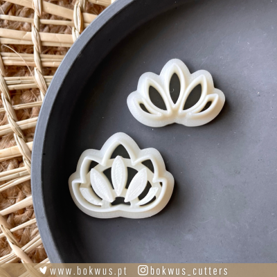 Dois cortadores de massa em formato de flor de lótus sobre prato cinza escuro