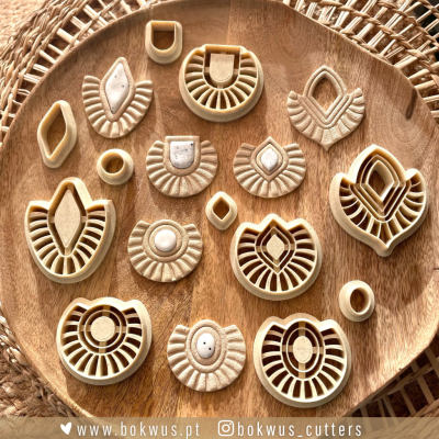 Conjunto de cortadores de massa amarelos e brancos em forma geométrica sobre bandeja de madeira