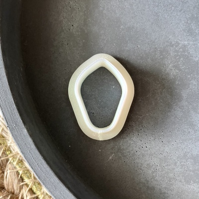 Anel branco translúcido num recipiente cinza escuro
