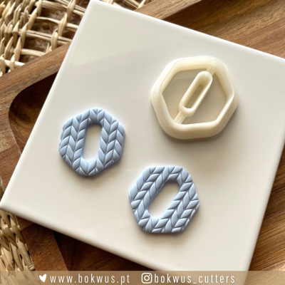 Cortantes de massa de forma hexagonal azul claro e branco sobre prato branco