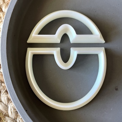 Dois cortadores de biscoito brancos ovais sobre prato cinza