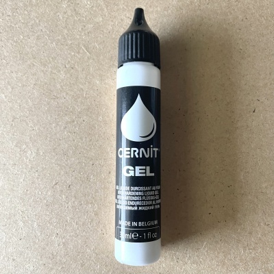 Frasco pequeno de gel durabilizador de unhas CERMIT GEL em fundo castanho claro