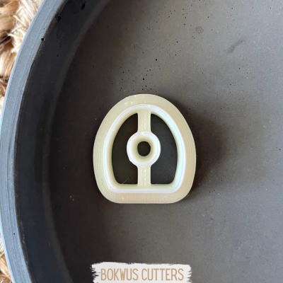 Cortador de biscoitos branco em prato cinzento com etiqueta BOKWUS CUTTERS