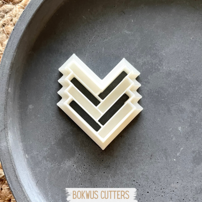 Conjunto de cortantes de plástico branco em forma de coração sobre prato cinzento