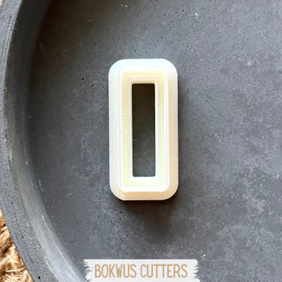 Cortador rectangular branco sobre prato escuro com texto BOKWUS CUTTERS