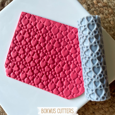 Rolo decorativo e folha de massa com padrão de corações