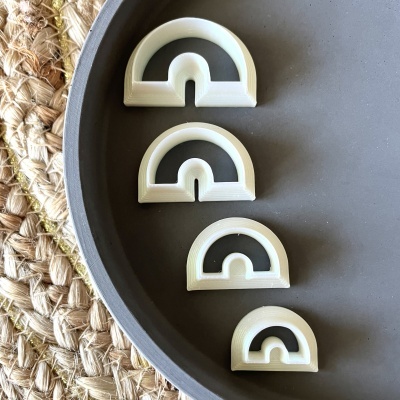 Cortadores de massa em plástico branco em prato cinza sobre tapete de fibras naturais