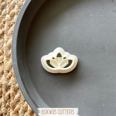 Cortador de bolacha flor branco sobre prato preto e tapete de fibras