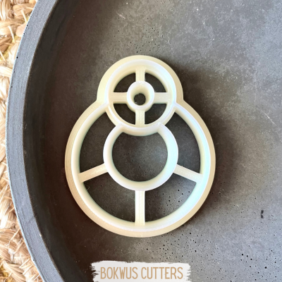 Cortador de bolachas redondo em plástico branco sobre prato cinzento com etiqueta BOKWUS CUTTERS