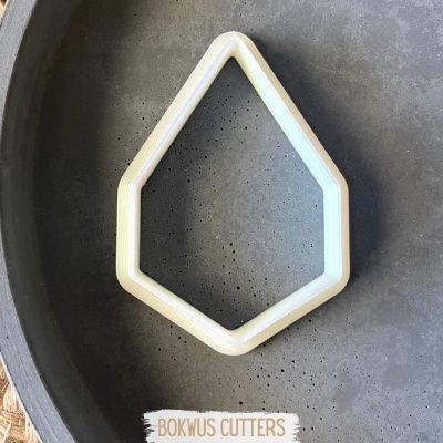 Cortador de massa branco em forma geométrica dentro de tigela cinza