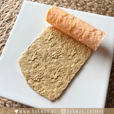 Carimbo de pasta polimérica com padrão floral sobre prato branco