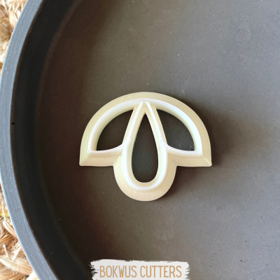 Cortador de biscoitos branco em prato escuro