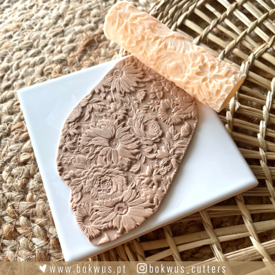 Rolo de textura floral para massa sobre massa modelada e superfície de palha.