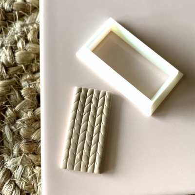 Duas peças de plástico branco com relevo sobre superfície clara