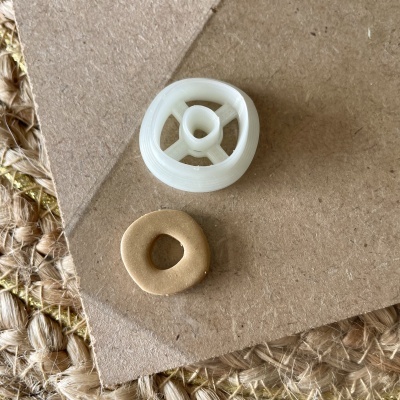 Duas peças circulares pequenas sobre cartão castanho e tapete de fibra natural