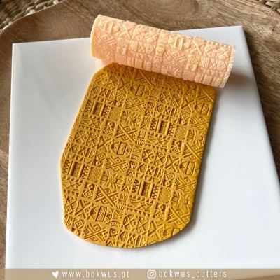 Molde de silicone com padrão geométrico laranja sobre prato branco em fundo de madeira