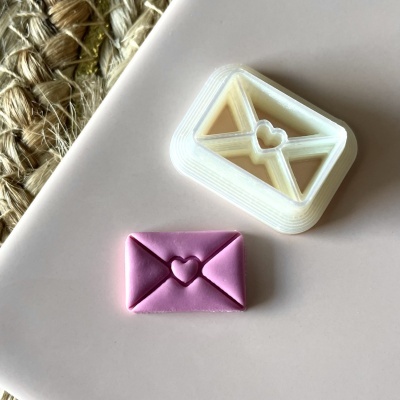 Carimbo de plástico branco e selo rosa com forma de envelope e coração