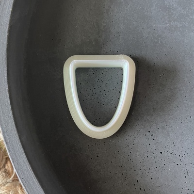 Argola D branca sobre superfície cinzenta texturada