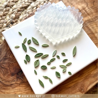 Cortadores de argila em forma de folhas verdes com molde translúcido relevo folhas