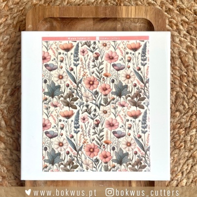 Caixa branca com padrão floral colorido sobre tabuleiro de madeira