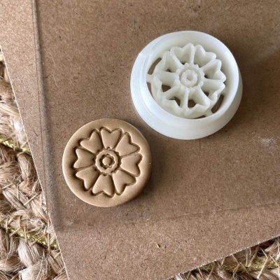 Carimbo branco com padrão floral e impressão em barro castanho sobre cartão