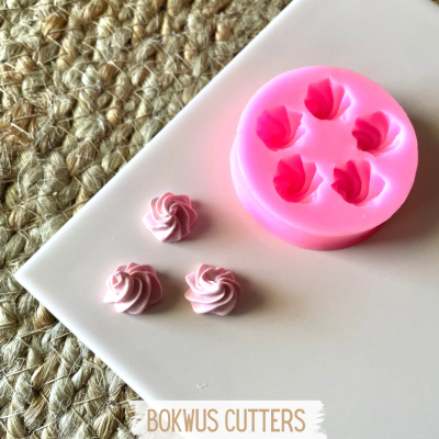 Forma de silicone rosa e decorações de pastelaria cor-de-rosa em superfície branca e base rústica