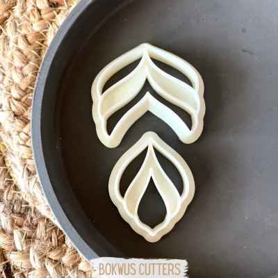 Cortadores de massa em forma de folhas em superfície preta redonda