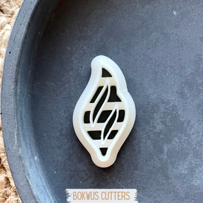 Cortador de massa em forma de pimenta branco sobre superfície escura