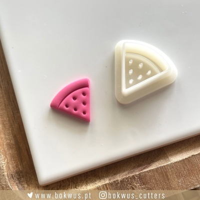 Dois cortadores de massa em forma de fatia de pizza, um rosa e outro branco, sobre fundo branco e madeira.