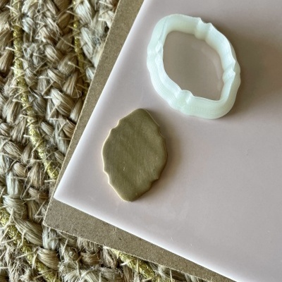 Cortante branco e massa moldada castanha sobre superfície rosa e tecido trançado