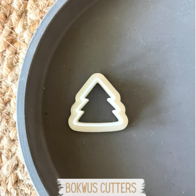 Cortador de biscoitos em forma de árvore de Natal branco numa placa cinzenta