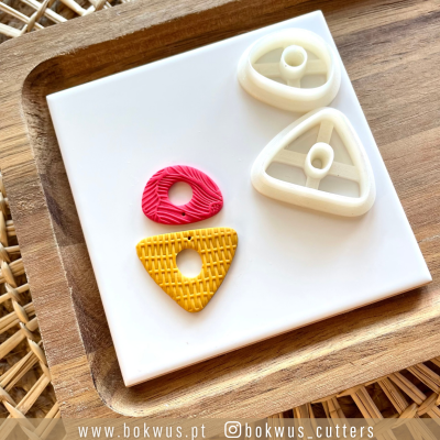 Cortadores triangulares brancos com peças amarelas e vermelhas texturizadas numa base branca