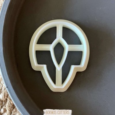 Cortador de biscoitos branco em forma geométrica na superfície preta