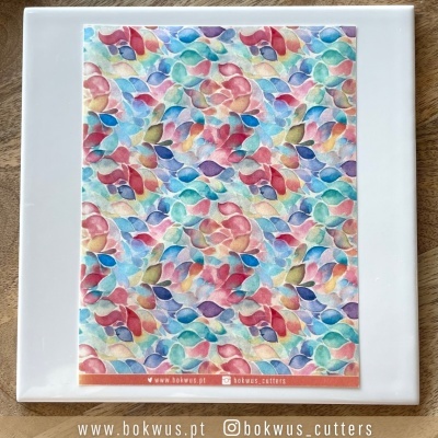 Peça quadrada branca com folha estampada colorida com texto www.bokwus.pt e bokwus_cutters